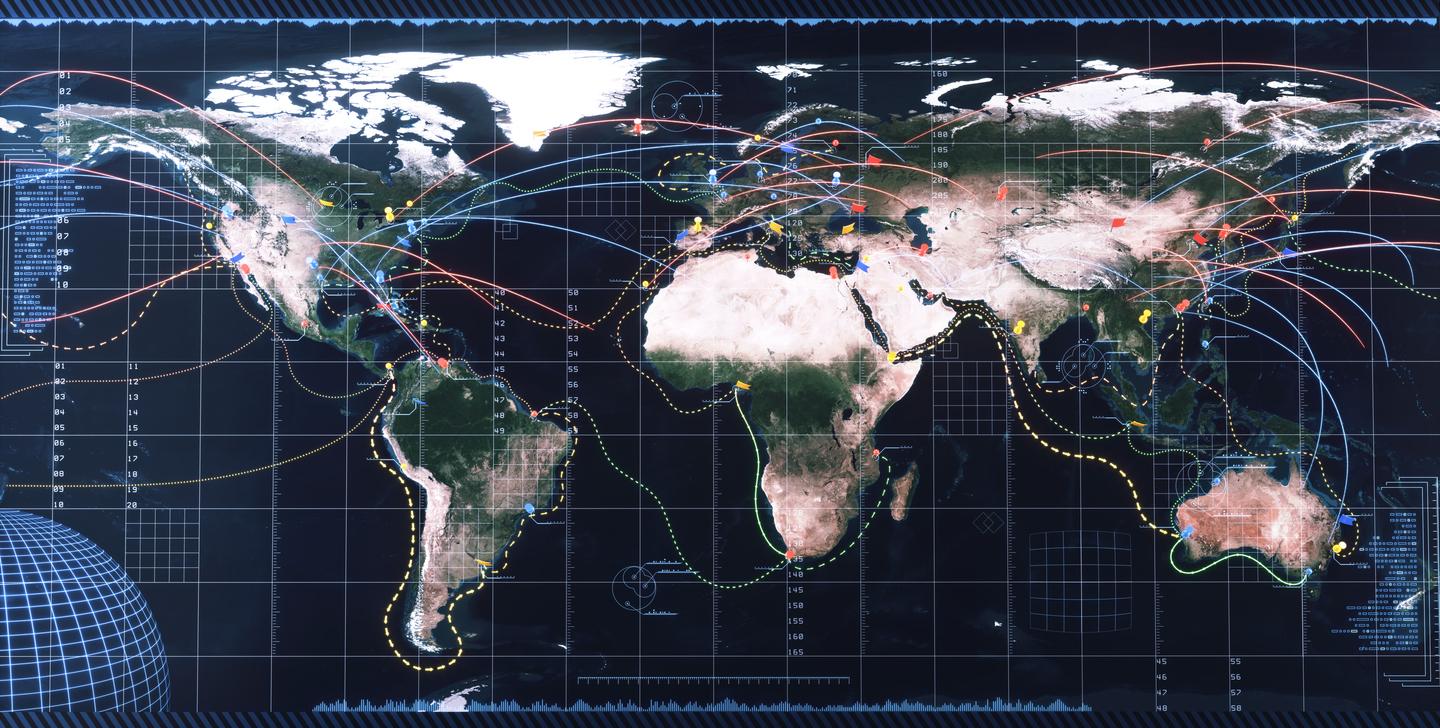 A detailed world map featuring various colored lines representing connections and routes across the globe. Different regions are marked with colored dots and symbols, indicating points of interest or data. The map has a grid overlay and includes a large globe in the lower left corner. The background has a high-tech feel, with digital interface elements and coordinates visible.