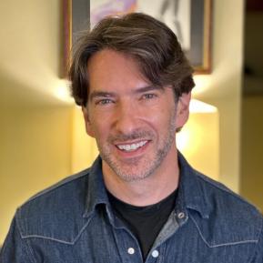 Image of male with brown hair wearing a denim jacket