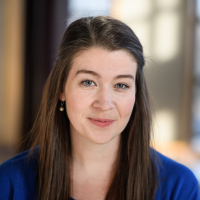 Image of female with brown hair, wearing a blue top.