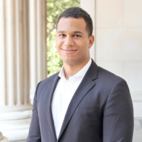 Image of male wearing a grey suit and white shirt