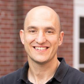 Image of bald male wearing a black t-shirt