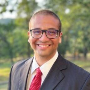 image of male wearing a grey suit and red tie