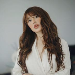 image of female with brown hair wearing a white shirt