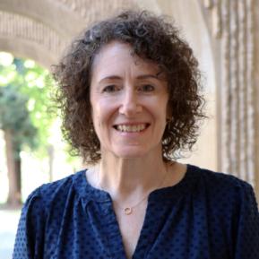 image of female with curly hair wearing a blue top