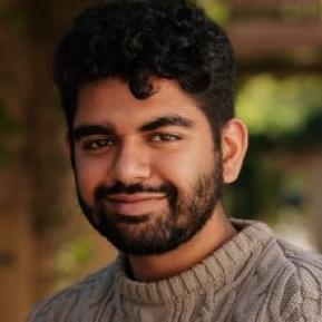 image of male with beard and mustache wearing a brown sweater