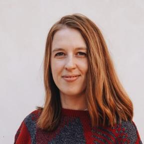 image of female with brown hair wearing a red and grey sweater