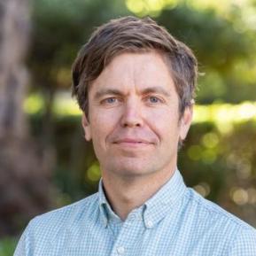 image of male wearing a blue collared shirt with brown hair 