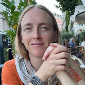 image of female with blonde hair wearing an orange tshirt