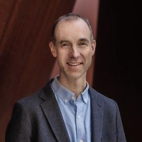 image of male wearing a grey suit and blue shirt