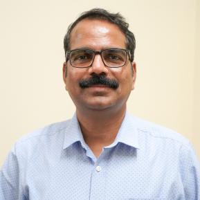 image of male with black glasses wearing a blue shirt