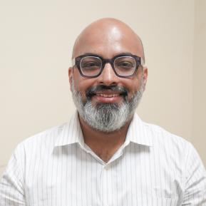 image of male with black glasses and grey beard wearing a white shirt