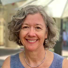 image of female wearing a blue top with grey and black hair