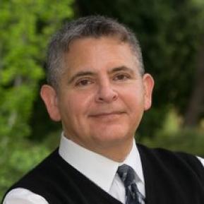 image of male wearing a white shirt and black vest