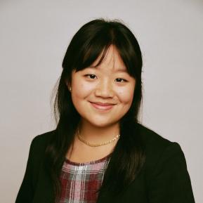 Image of female with black hair wearing a black blazer and checked top