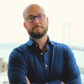 Image of male with glasses wearing a blue shirt