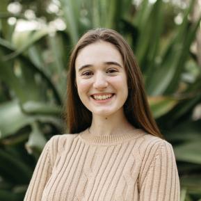 Image of female with brown hair wearing a beige sweater