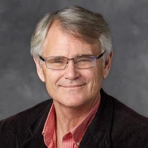 Image of male with white hair and glasses wearing a red shirt and black jacket