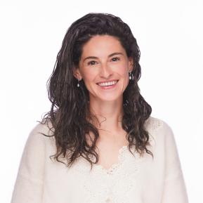 headshot of female with brown and grey hair wearing a white sweater