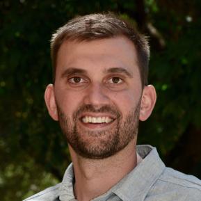 Image of male with beard wearing a grey shirt