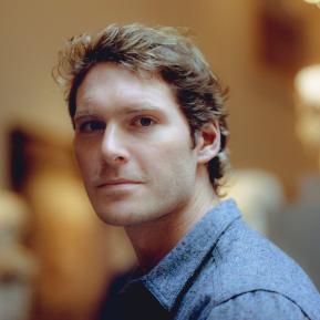 male with blonde hair wearing a blue shirt