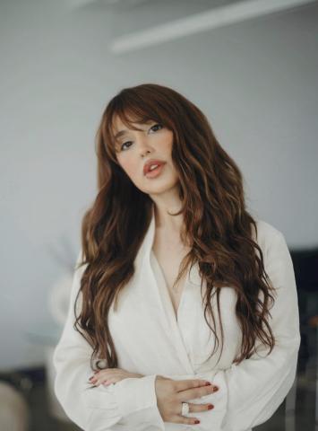 image of female with brown hair wearing a white shirt