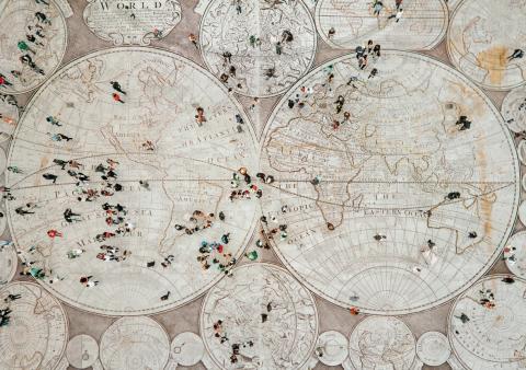 image of world map as the floor with people walking in different directions