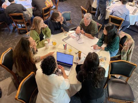 image of people sitting around a table in conversation