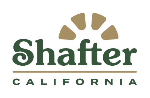 The image displays the logo for the city of Shafter, California. The design features the name "Shafter" in a stylish, bold font with a whimsical touch to the letter "S." Above the name, there are stylized sun rays represented in a muted gold color, symbolizing warmth and community. Below "Shafter," the word "CALIFORNIA" is presented in smaller, simple lettering. The color palette includes green for the text and a warm gold for the sun rays, evoking a natural and inviting feel that reflects the local environ