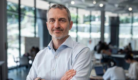 man wearing blue shirt standing with arms crossed