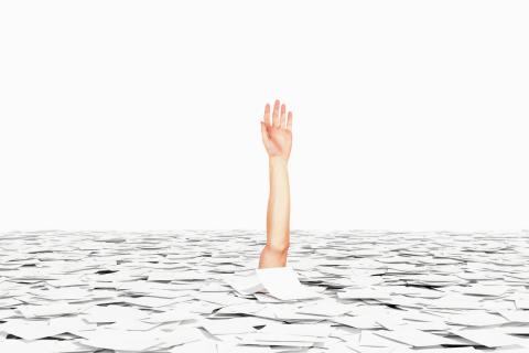 arm drowning in a sea of papers