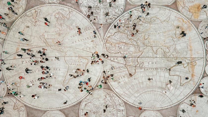 image of world map as the floor with people walking in different directions