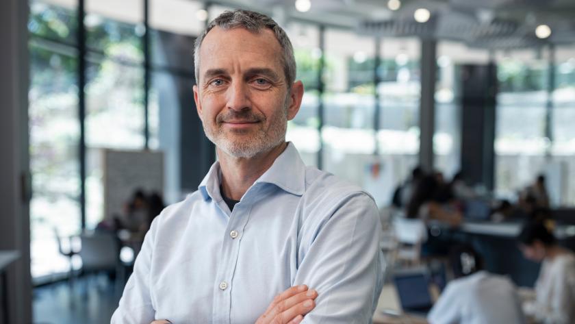 man wearing blue shirt standing with arms crossed