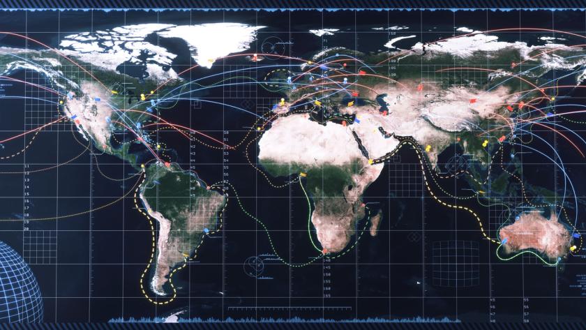 A detailed world map featuring various colored lines representing connections and routes across the globe. Different regions are marked with colored dots and symbols, indicating points of interest or data. The map has a grid overlay and includes a large globe in the lower left corner. The background has a high-tech feel, with digital interface elements and coordinates visible.