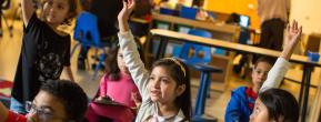 Children raising their hands in class