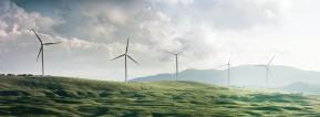 Several wind turbines on a grassy hill