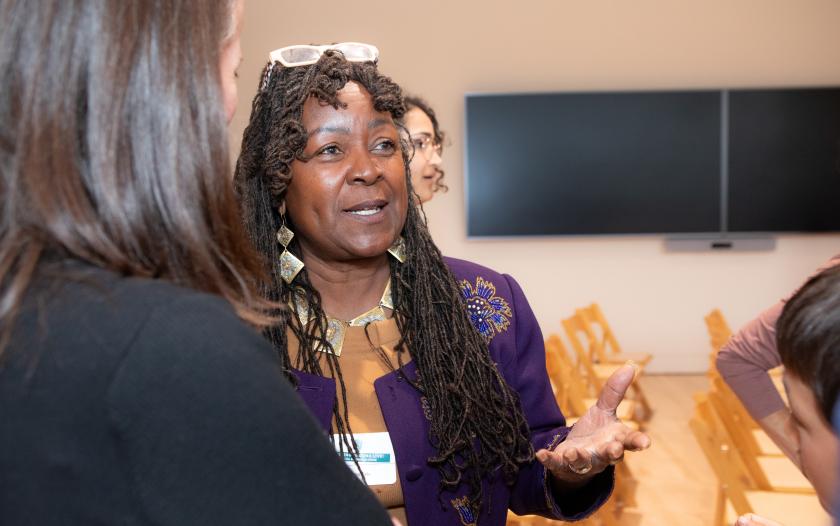 image of female wearing a purple jacket talking to people